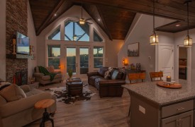Skyfall | Cabin Rentals of Georgia | Open-concept great room with vaulted ceilings, floor-to-ceiling windows, and stone fireplace