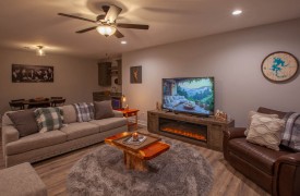 Skyfall | Cabin Rentals of Georgia | Terrace Level living area with electric fireplace, plenty of seating, TV, wet bar, and game table